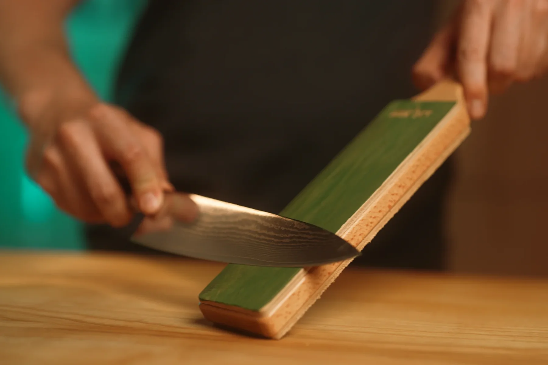 Knife being honed on a leather paddle strop